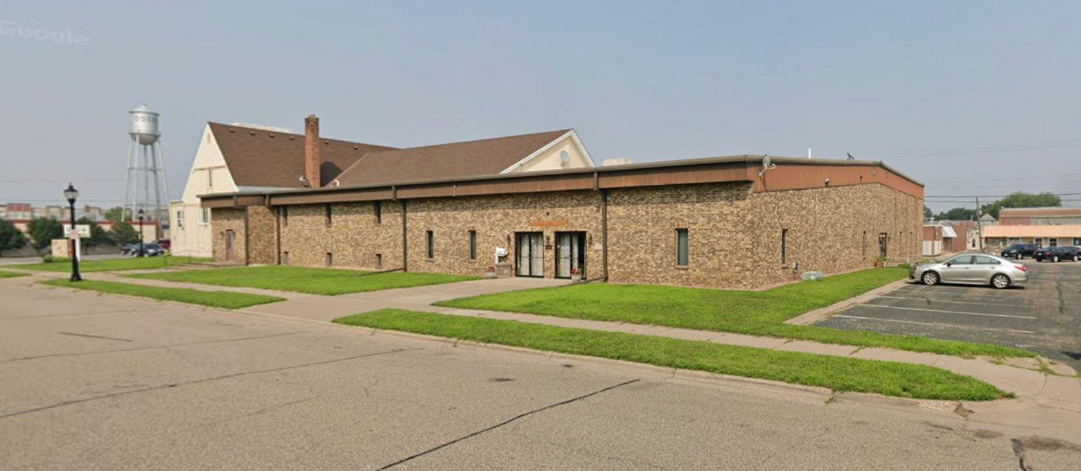 Minnesota Meditation Center building exterior at 224 1st Ave NW Osseo MN - brick building with parking lot on right side